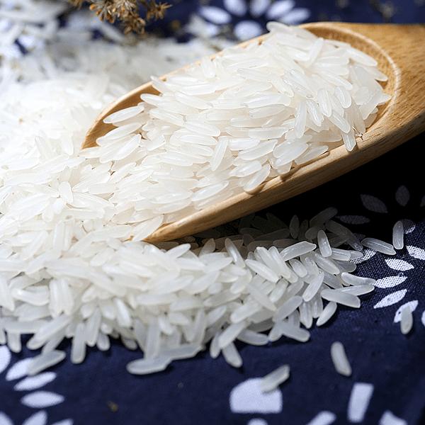 White rice on a wooden spoon over a blue cloth
